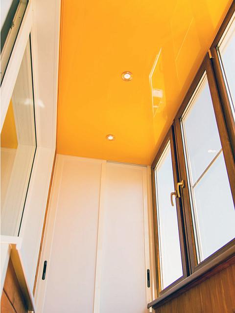 жёлтый глянцевый потолок на балконе